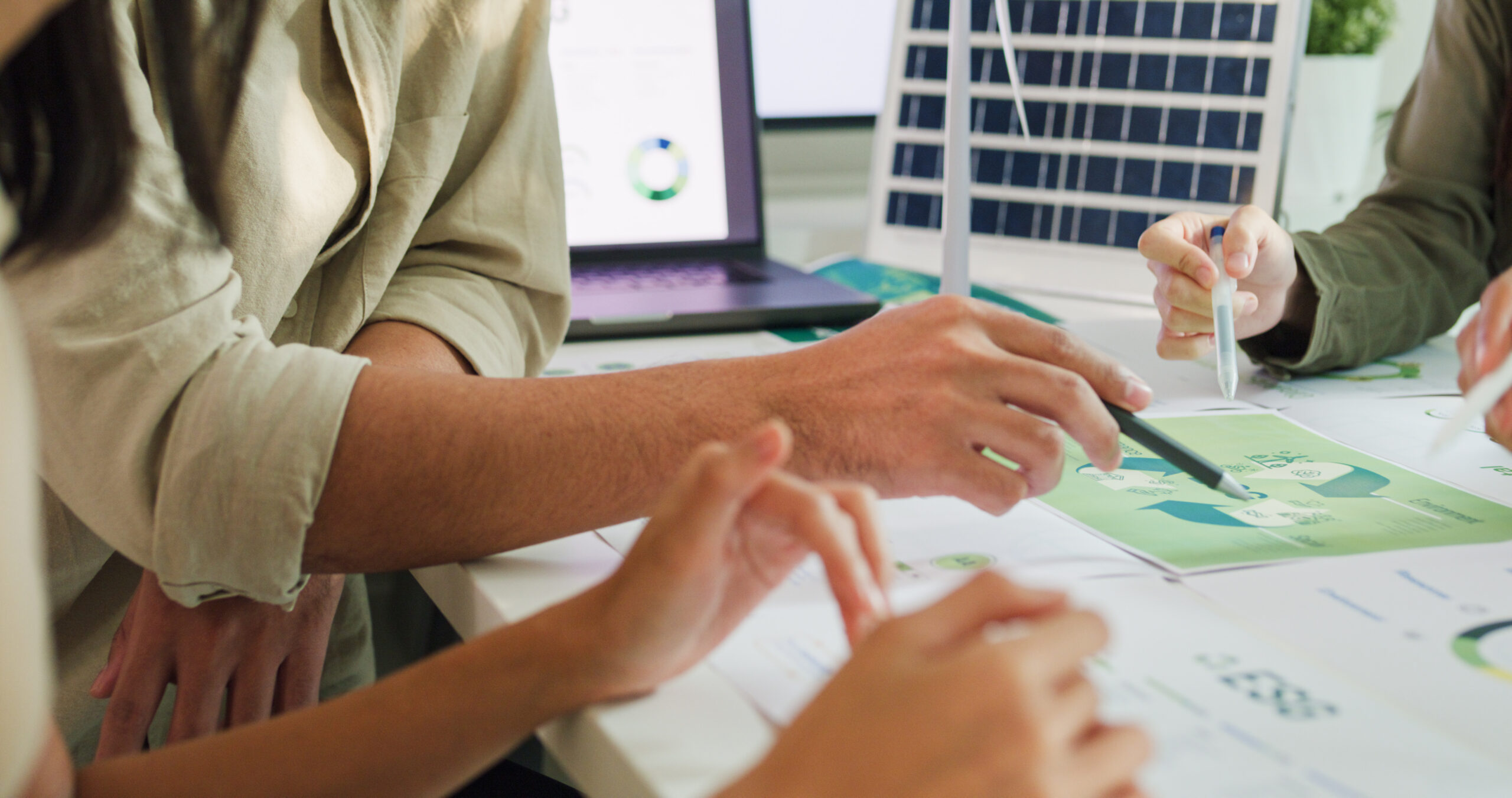A close-up of a team collaborating and pointing at ESG infographics.